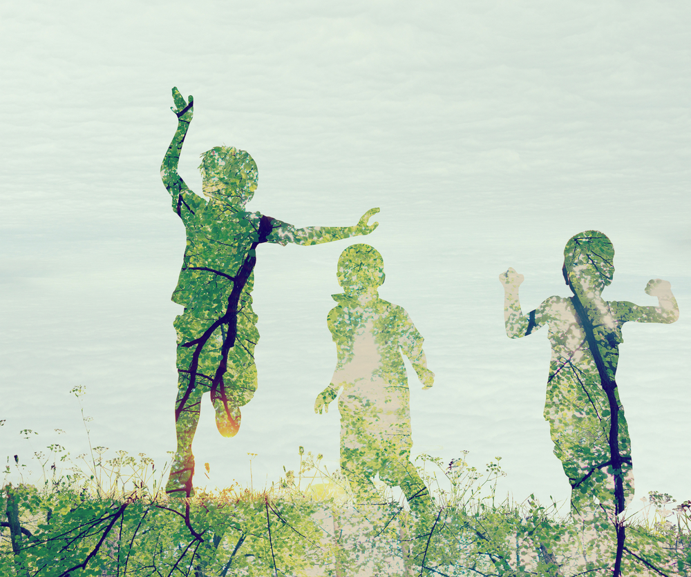 Children running on meadow at sunset double exposure